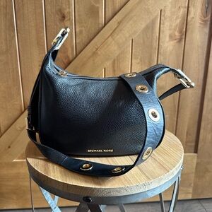 Small medium, Michael Kors, black Crossbody purse with a pocket on the inside